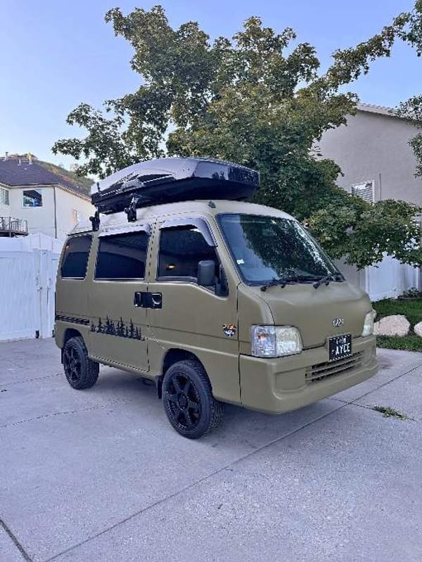 Front and side profile of the olive-green Subaru Sambar that Tyler details out of