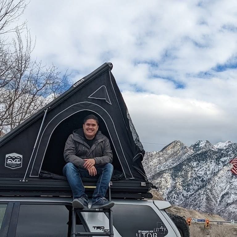 Matthew camping in his rooftop tent in the Utah mountains